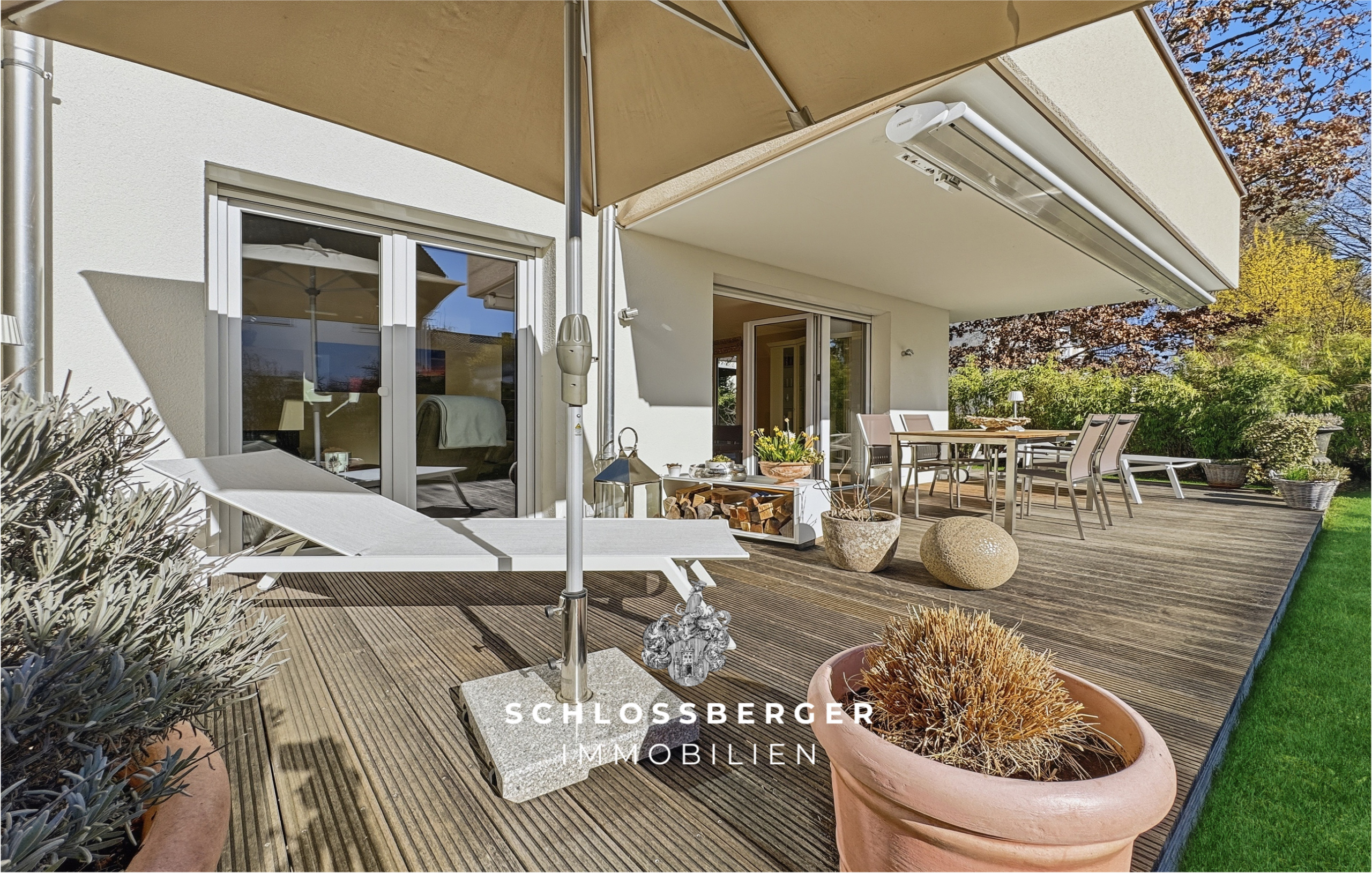 Terrasse mit Sonnenschirm und Holzdeck im Garten
